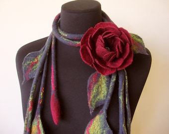 May include: A gray felt scarf with a large red felt rose and green leaves. The scarf is displayed on a black mannequin.