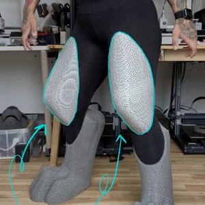 May include: A pair of gray, textured, three-dimensional leg and foot padding pieces worn over black leggings. The padding features a distinct, mesh-like surface pattern. Text at the bottom reads: THIS LISTING IS FOR PADDING ONLY! PLEASE SEE MY OTHER LISTINGS FOR VARIOUS BOOT SHAPES!