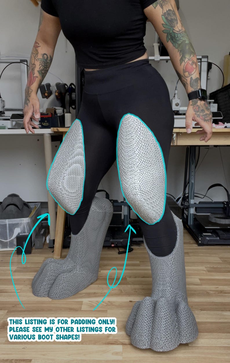 May include: A pair of gray, textured, three-dimensional leg and foot padding pieces worn over black leggings. The padding features a distinct, mesh-like surface pattern. Text at the bottom reads: THIS LISTING IS FOR PADDING ONLY! PLEASE SEE MY OTHER LISTINGS FOR VARIOUS BOOT SHAPES!