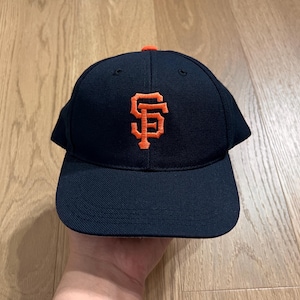 May include: A black baseball cap with an orange "SF" logo.