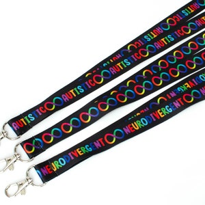 May include: Four black lanyards with rainbow infinity symbols and the words "AUTISTIC" and "NEURODIVERGENT" printed on them. Each lanyard has a silver clip.