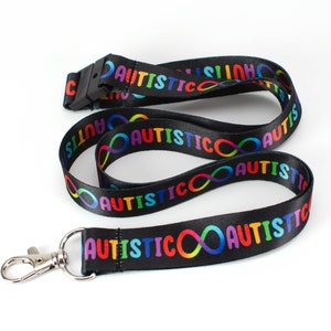 May include: Black lanyard with a rainbow infinity symbol and the word "AUTISTIC" repeated along the length. The lanyard has a silver clip.