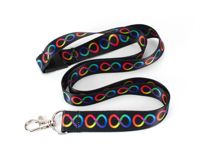 May include: A black lanyard with a rainbow infinity symbol design. The lanyard has a silver clip and a black plastic buckle.