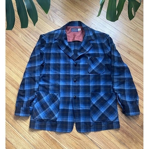 May include: A blue and brown plaid flannel jacket with a button-up front and two patch pockets on the front.