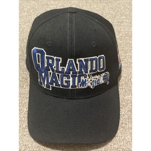 May include: A black baseball cap with a blue and white embroidered Orlando Magic logo. The logo includes the team name and a basketball.