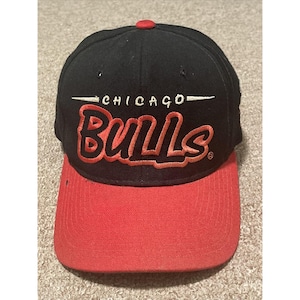 May include: Black and red baseball cap with the text "CHICAGO BULLS" embroidered on the front.