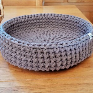 May include: A grey crocheted basket with a white tag that says "Made with Love".