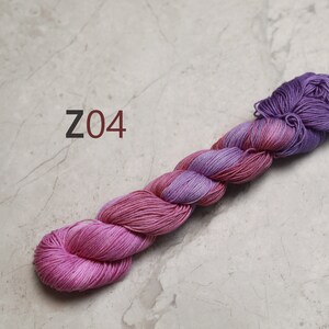 May include: A skein of pink and purple yarn with the text "Z04" in the background. visible creative mending thread