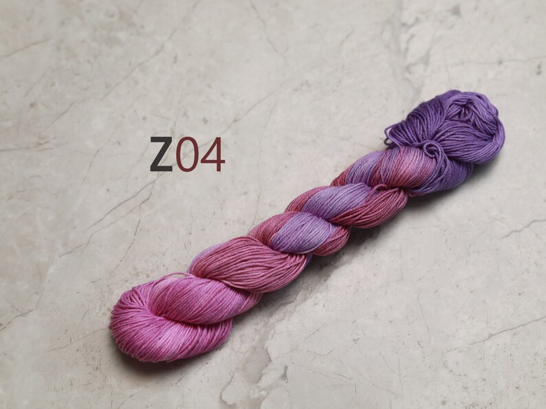 May include: A skein of pink and purple yarn with the text "Z04" in the background. visible creative mending thread