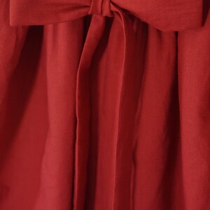 Puede incluir: Un vestido rojo con un gran lazo en la cintura.