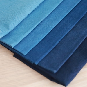 May include: A stack of fabric swatches in various shades of blue, ranging from light to dark.
