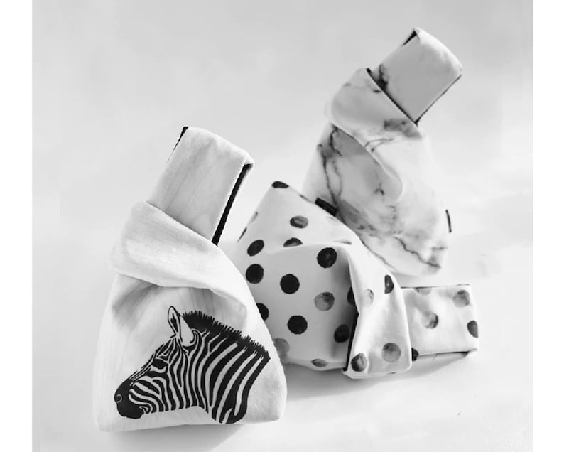 Pu&ograve; includere: Tre borse di tessuto con motivi diversi. Una borsa ha una stampa zebra in bianco e nero, un'altra ha pois neri su sfondo bianco e la terza ha un motivo a marmo bianco.