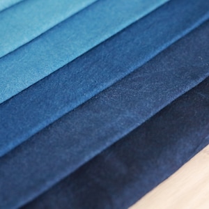 May include: A stack of fabric swatches in various shades of blue, ranging from light to dark.