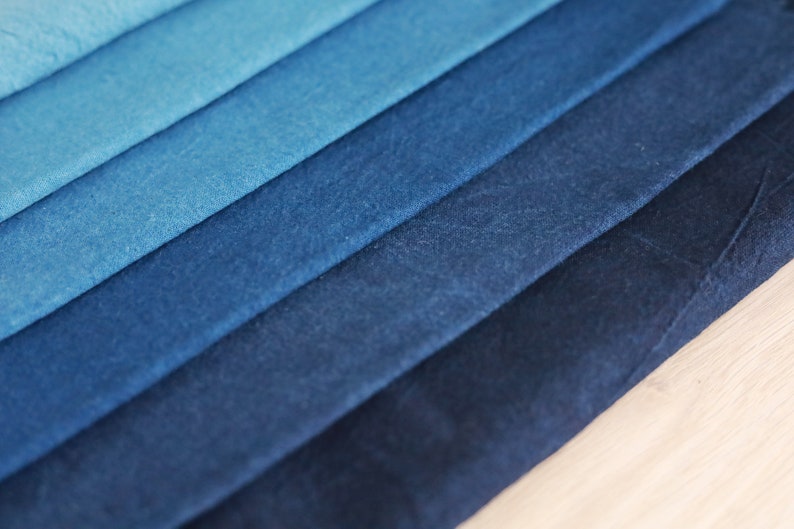 May include: A stack of fabric swatches in various shades of blue, ranging from light to dark.