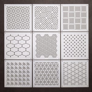 Può includere: Nove piastrelle quadrate bianche con diversi motivi geometrici neri. Ogni piastrella ha un motivo diverso, tra cui linee, punti e forme.