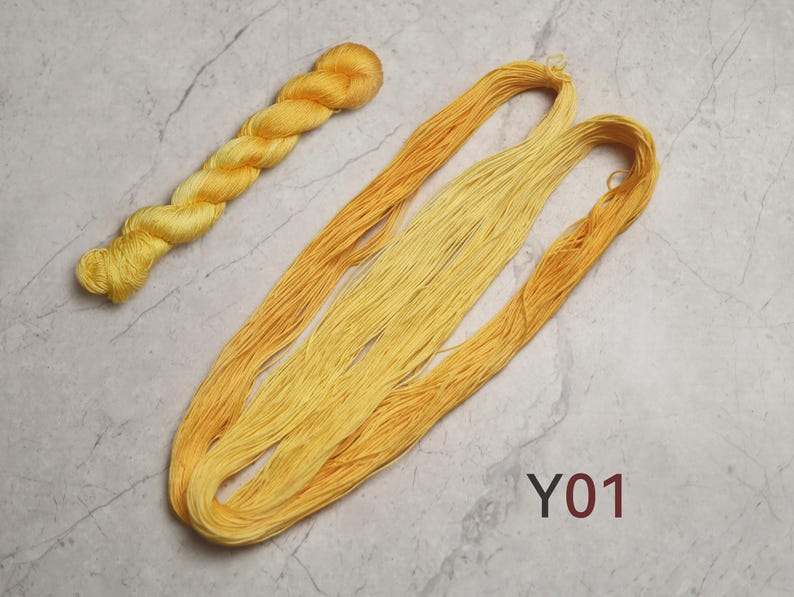 May include: A twisted skein of bright yellow yarn and a long, loose hank of yellow embroidery thread featuring a gradient of shades from light to dark. The text Y01 is printed in dark red in the lower right corner of the image.