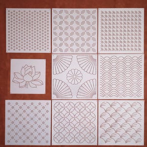 Peut inclure: Neuf pochoirs carrés blancs avec différents motifs géométriques, dont une fleur, des vagues et divers motifs répétitifs.