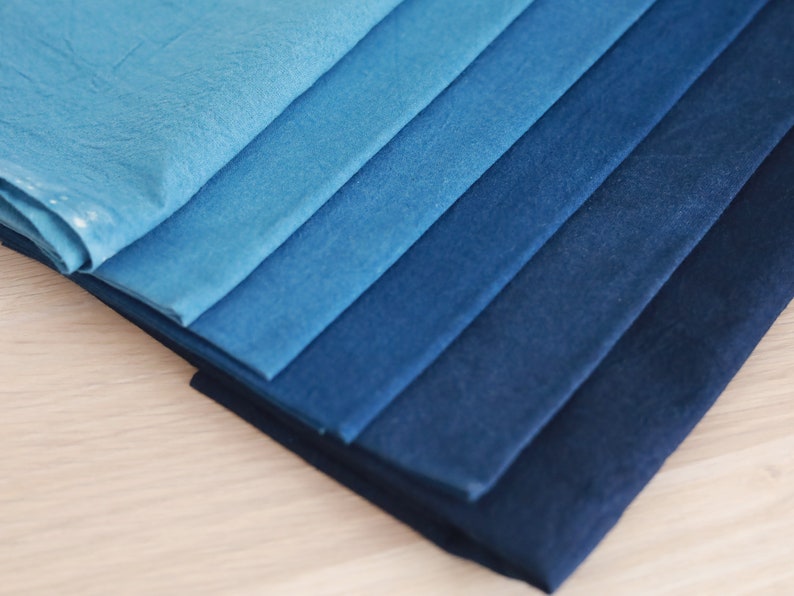 May include: A stack of fabric swatches in various shades of blue, ranging from light to dark.