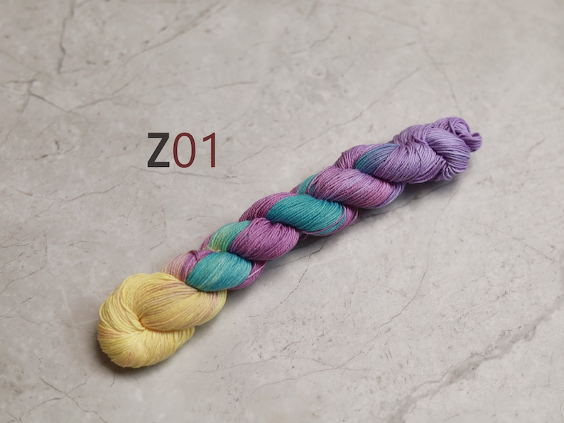 May include: A skein of yarn in shades of yellow, teal, and purple. The yarn is twisted into a rope shape and labelled "Z01". visible creative mending thread