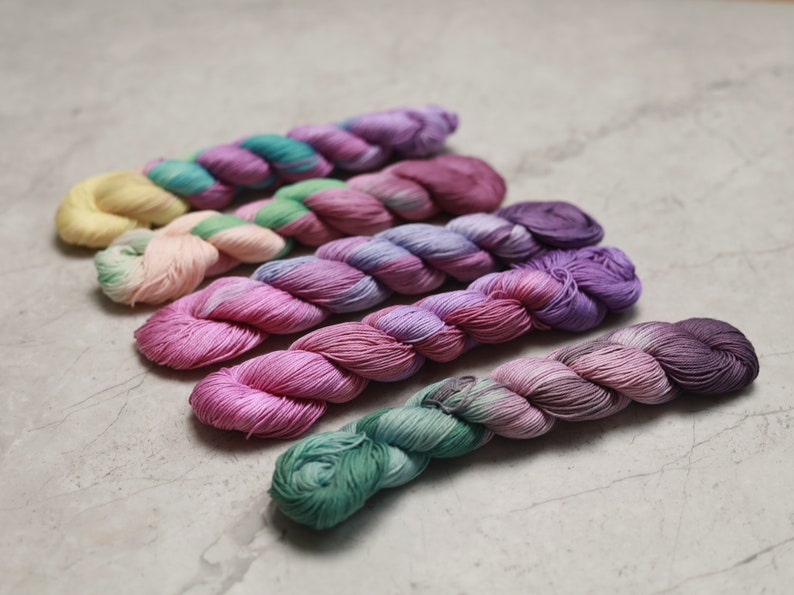 May include: Six skeins of yarn in various shades of pink, purple, green, and yellow. The yarn is twisted and has a soft, fuzzy texture. visible creative mending sashiko thread quilting thread