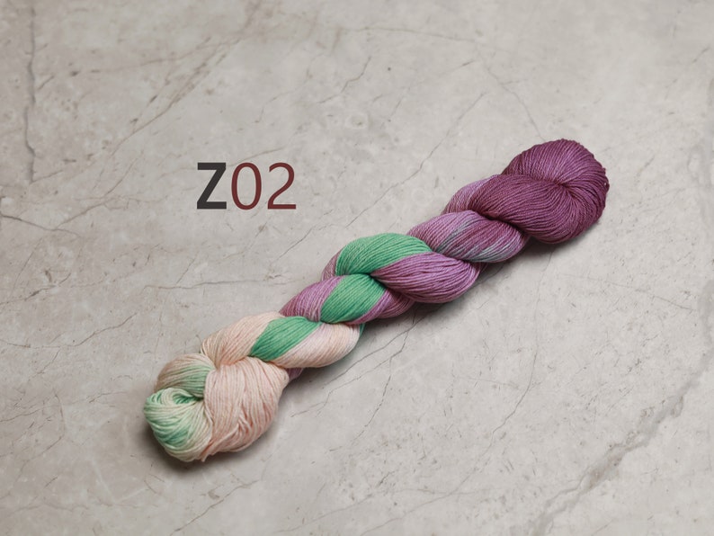May include: A skein of yarn in shades of pink, green, and cream. The yarn is twisted into a rope shape and the label "Z02" is visible.