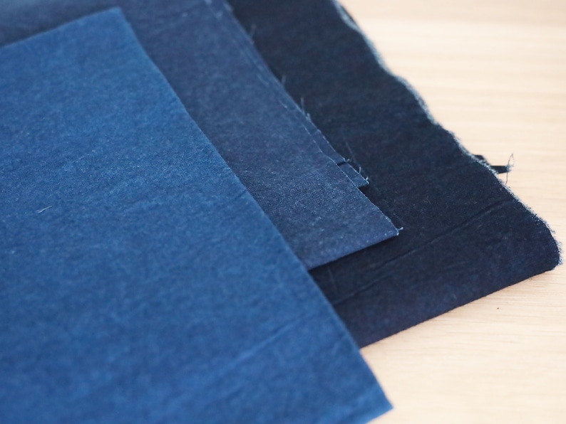May include: Three pieces of indigo dyed fabric in different shades of blue, from light to dark.