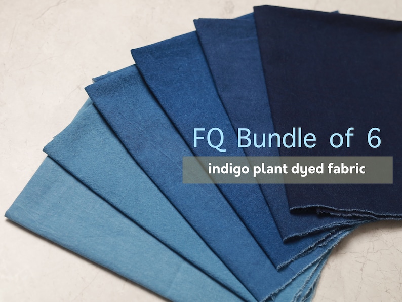 May include: A bundle of six indigo plant dyed fabric squares in various shades of blue, from light to dark. The fabric is arranged in a fan shape. The text "FQ Bundle of 6 indigo plant dyed fabric" is displayed on the fabric.
