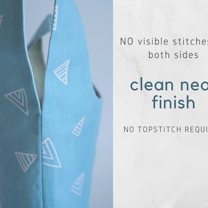 Pu&ograve; includere: Primo piano di un tessuto blu chiaro con un motivo geometrico bianco. Il tessuto &egrave; piegato a met&agrave;, mostrando la finitura pulita e ordinata della cucitura. Il testo "NO visible stitches on both sides clean neat finish NO TOPSTITCH REQUIRED" &egrave; visibile sul lato destro dell'immagine.