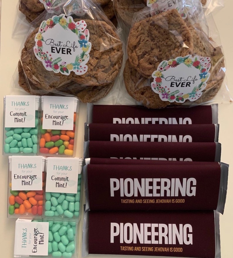 May include: An assortment of treats, including large cookies in clear bags with floral "Best Life Ever" stickers, mints in clear boxes with "Thanks for your Commit Mint!" and "Encourage Mint!" labels, and maroon chocolate bars labeled "PIONEERING".