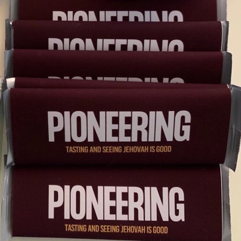 May include: A stack of maroon-colored paper items with the word "PIONEERING" in large white letters. Below the word is the text "TASTING AND SEEING JEHOVAH IS GOOD". The top of the stack has the word "PIONEERING" repeated.