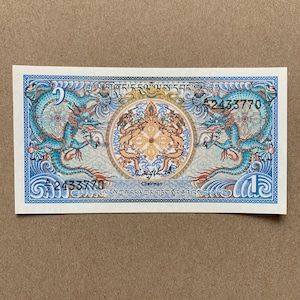 Bhutanese One Ngultrum Banknote. Bhutan Currency, known as Game of Thrones Note. Asian Bills. Royal emblem between facing dragons at center.