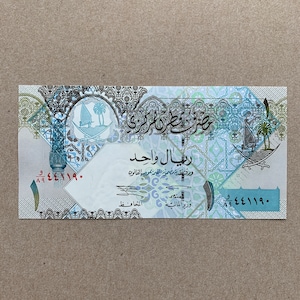 Katar 1 Riyal Banknote. Katar Währung. Die Haubenlerche, der Bienenfresser und der Flussregenpfeifer. Wasserzeichen, Falkenkopf. Papiergeld.