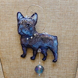 Può includere: Un ornamento in vetro blu e viola a forma di bulldog francese con un collare argentato e un ciondolo di cristallo. L'ornamento è appeso a un filo d'argento.