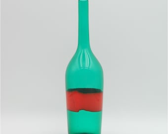 May include: A tall, slender green glass bottle with a long neck and a red band around the middle. The bottle has a classic shape, suitable for decorative purposes. The bottle is empty and stands against a white background.