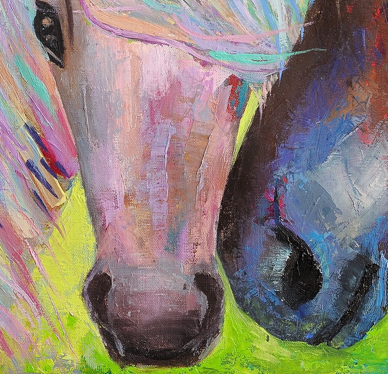 May include: A close-up of two horses' faces, one with a pink and purple mane and the other with a blue and black mane. The horses' noses are touching, and the background is a green field.