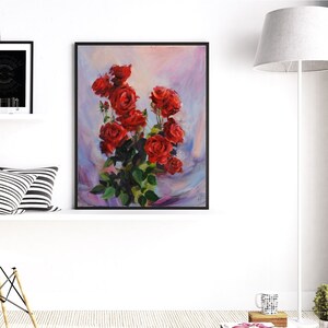 May include: A framed painting of a bouquet of red roses with green leaves. The artwork features a vibrant display of flowers against a soft, blended background of pink, blue, and purple hues. The painting is in a black frame.