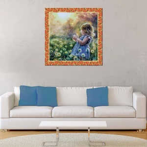 May include: A framed print depicting a young child in a blue dress blowing dandelion seeds in a field. The frame is orange with a decorative pattern. The background is a soft, blurred landscape.