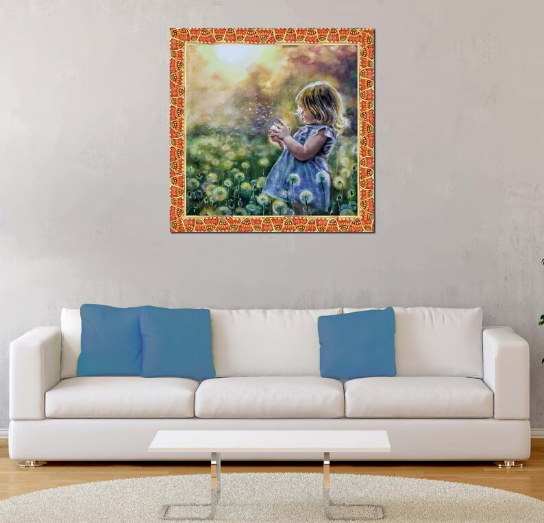 May include: A framed print depicting a young child in a blue dress blowing dandelion seeds in a field. The frame is orange with a decorative pattern. The background is a soft, blurred landscape.