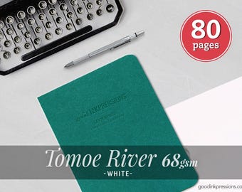 May include: A teal notebook with the embossed text good INKPRESSIONS LETTERPRESS handmade stationery, a silver mechanical pencil, a typewriter, and a red circular graphic with the white text 80 pages. The text Tomoe River 68gsm -WHITE- is visible.