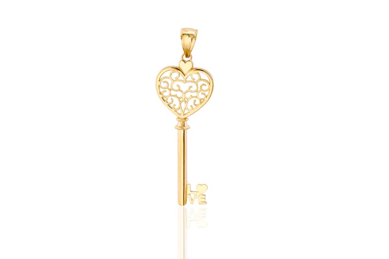 Op de afbeelding: Een gouden sleutelhanger met een hartvormig sleutelgat en het woord "LOVE" onderaan.