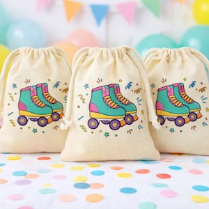 Op de afbeelding: Drie beige trekkoordzakken met een kleurrijk rolschaatsontwerp. De rolschaatsen zijn turquoise, geel en roze, met paarse wielen. De zakken zijn versierd met confetti en sterren, perfect voor een feestje.