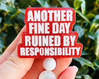 May include: Red glitter badge holder with the text "Another Fine Day Ruined By Responsibility" in white letters. The badge holder has a white and clear beaded chain with a clear plastic clip.