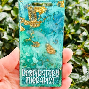 May include: A teal blue and gold resin badge with the text "Respiratory Therapist" in white lettering.