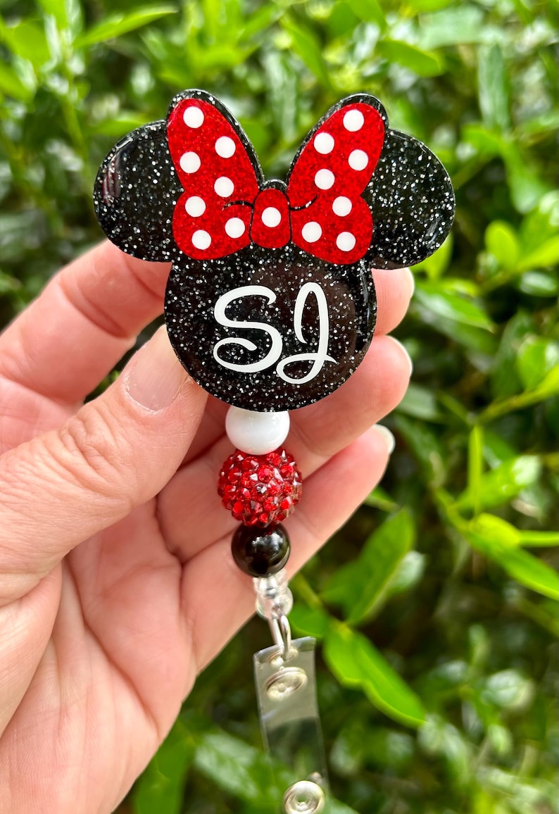 May include: Black and red glitter Minnie Mouse themed badge holder with the initials "SJ" and a red rhinestone charm.