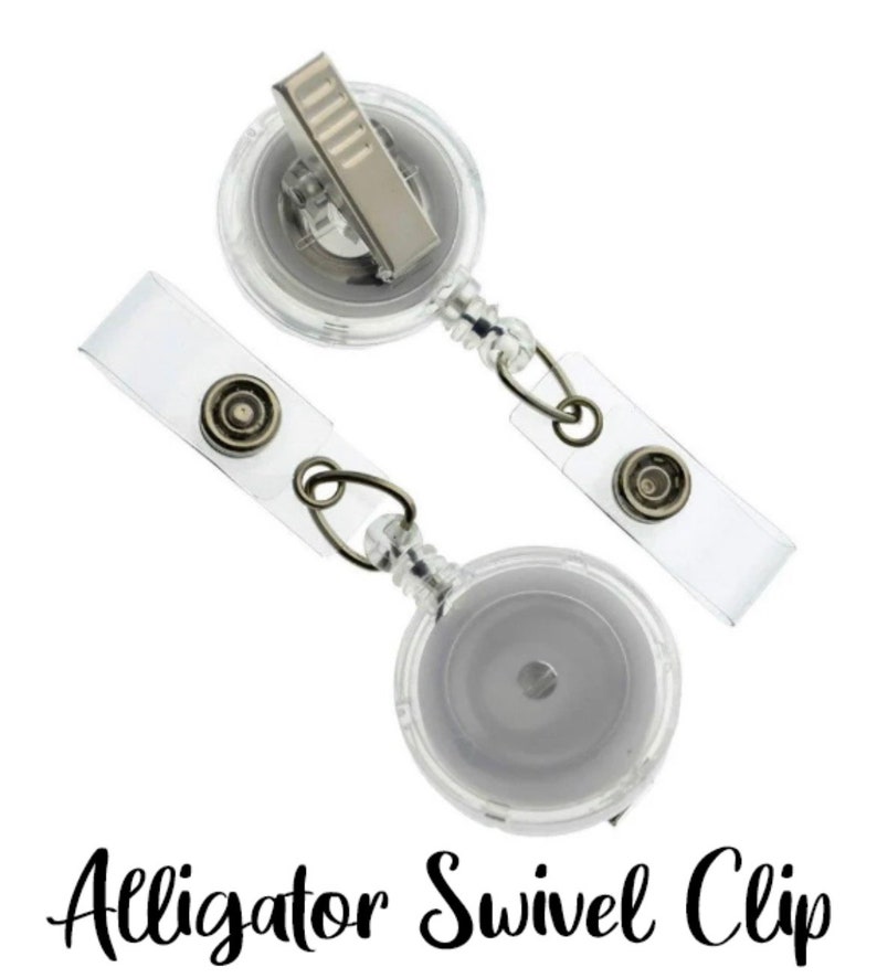 May include: Two clear retractable badge holders with alligator swivel clips. The holders have a clear plastic body and a silver metal clip.