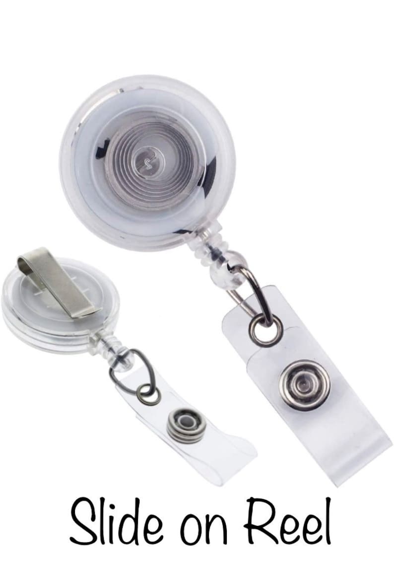 May include: Two clear plastic retractable badge holders with a silver clip and a slide-on reel. The text "Slide on Reel" is written below the holders.