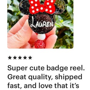 May include: A black and red Minnie Mouse-themed badge reel with the name "LAUREN" written in white on the front. The reel is decorated with red and white polka dots.