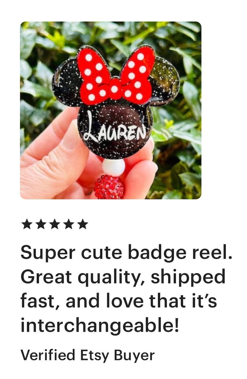 May include: A black and red Minnie Mouse-themed badge reel with the name "LAUREN" written in white on the front. The reel is decorated with red and white polka dots.