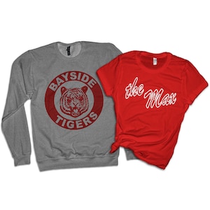 May include: Two t-shirts, one gray with a red circle and the words "Bayside Tigers" and a red tiger inside the circle, and one red with the words "the Max" in white.
