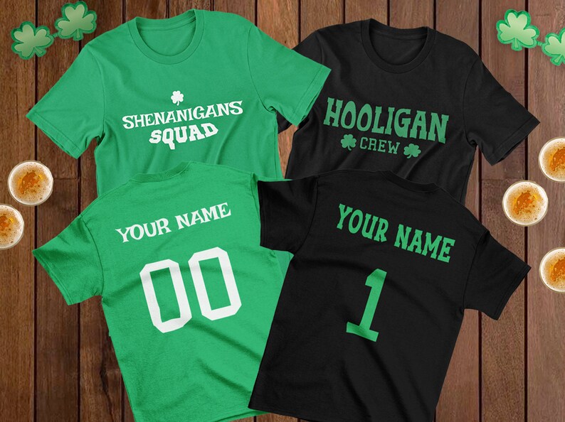 Puede incluir: Cuatro camisetas verdes y negras con dise&ntilde;os de tr&eacute;boles. Dos camisetas dicen "Shenanigans Squad" y las otras dos dicen "Hooligan Crew". Dos camisetas tienen el texto "Your Name" y un n&uacute;mero en la espalda.